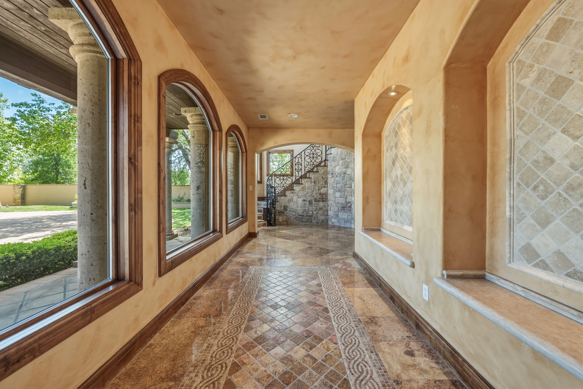 As you open the exquisite wrought iron doors, decorative granite floors grace the foyer with large windows.