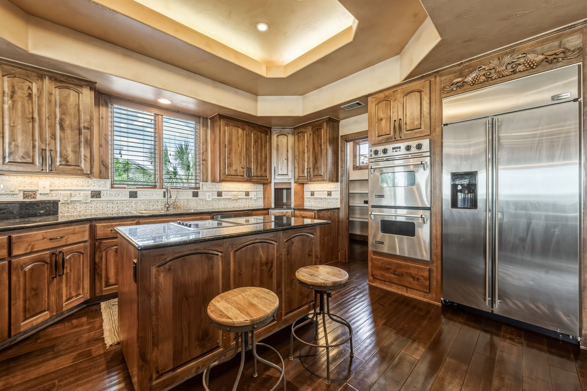 The kitchen features hardwood flooring, knotty alder cabinetry, granite countertops, and stainless steel appliances.