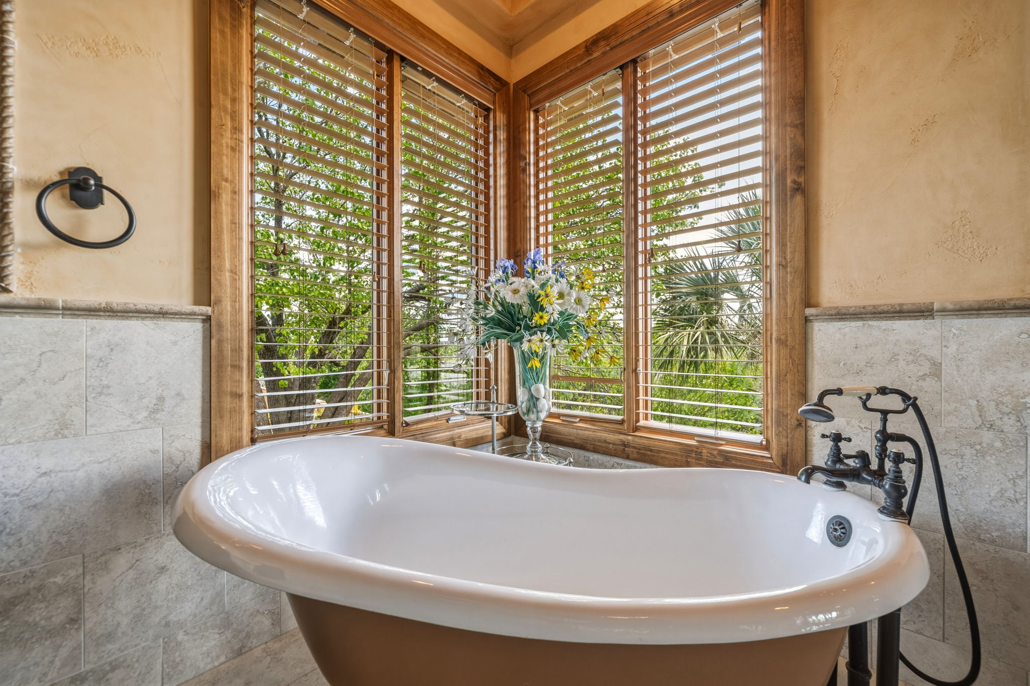 Relax in your freestanding clawfoot tub with windows providing  natural light.