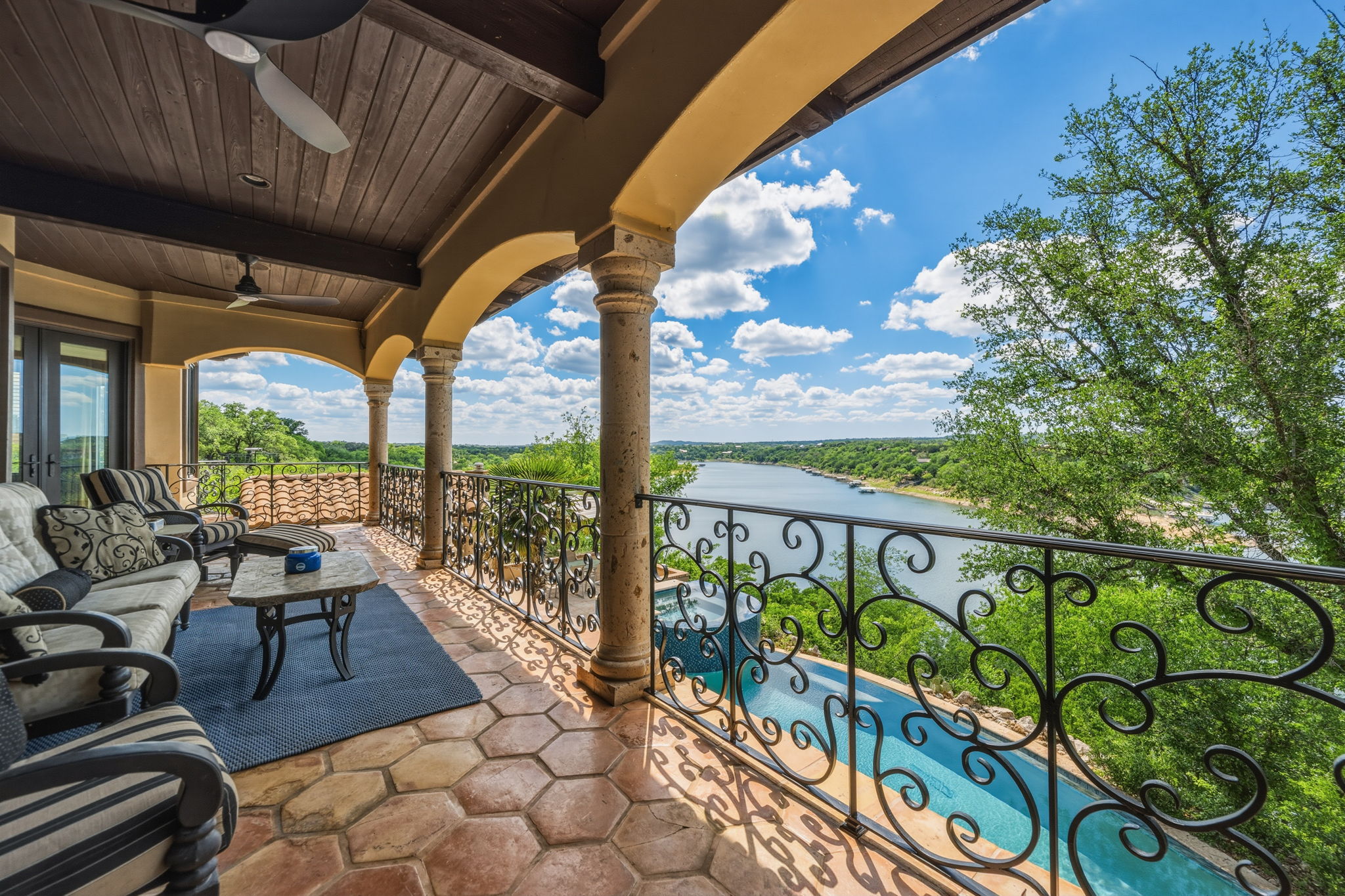 Spectacular views from the expansive covered porch with patterned tile flooring and stone pillars.