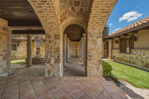 Walk through the stone columns to enter the garage to the right  or the side courtyard to the left.