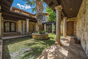 Side courtyard shows main entrance door to the left and a cedar room to the right for storage.