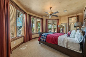 Views of the lakeside with carpeting, multiple windows with blinds, and an overhead ceiling fan.