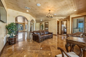 Your guests may enjoy the lower level living area with polished stone flooring, arched doorways, and decorative columns.