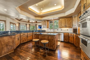 The gourmet kitchen features knotty alder cabinetry, granite countertops, and stainless steel appliances, including double ovens and a refrigerator.