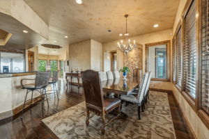 Dining area provides waterfront views and features hardwood floors, a chandelier,