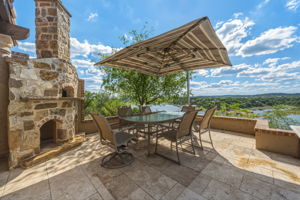 Striking lake views next to the custom rustic wood-fired  pizza oven.  Expansive outdoor patio featuring flagstone flooring.