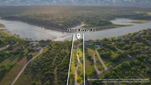 The property features an extensive lot with a private driveway, a lush green landscape, and direct access to the water.