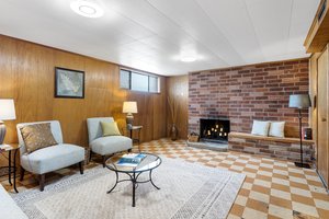 Below, discover this large rec room with a second fireplace.