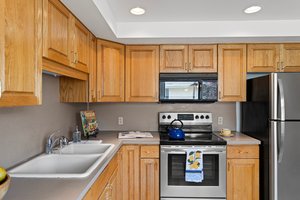 The spacious kitchen boasts newer solid oak cabinets that offer plenty of storage and a touch of rustic charm.