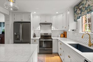 The Kitchen also features custom cabinetry, quartz counter tops, and a tile backspash