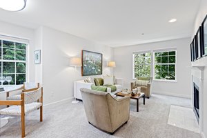 Step into the living room, where nature paints a lush green vista beyond the windows. As an end unit, abundant natural light floods the space, creating a warm and inviting ambiance.