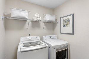 The generous laundry room features new luxury vinyl flooring and LED lighting for an inviting atmosphere. The brand-new washer and dryer promise efficiency and convenience, making laundry a breeze.