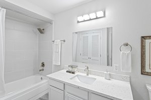 Step into the beautifully-updated bathroom, where every detail has been carefully considered. The new quartz countertop, bottom-mount sink, and sleek faucet add a touch of modern elegance. The tiled shower surround and hardware create a spa-like experience, while LED lighting illuminates the space. Underfoot, luxury vinyl flooring ensures both style and practicality, all designed with accessibility in mind.