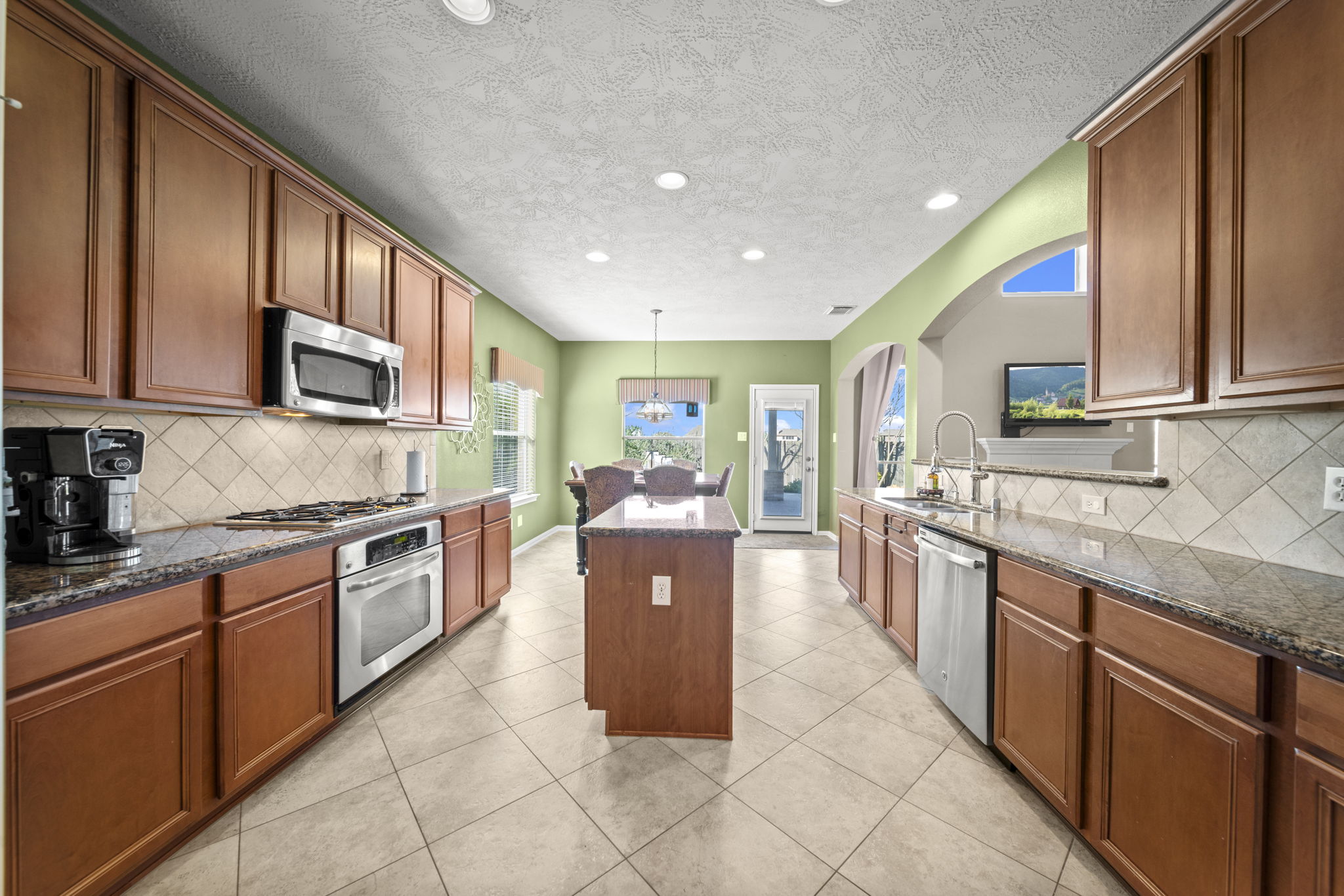 Spacious kitchen with recessed lighting, tile flooring/backsplash and a walk-in pantry!