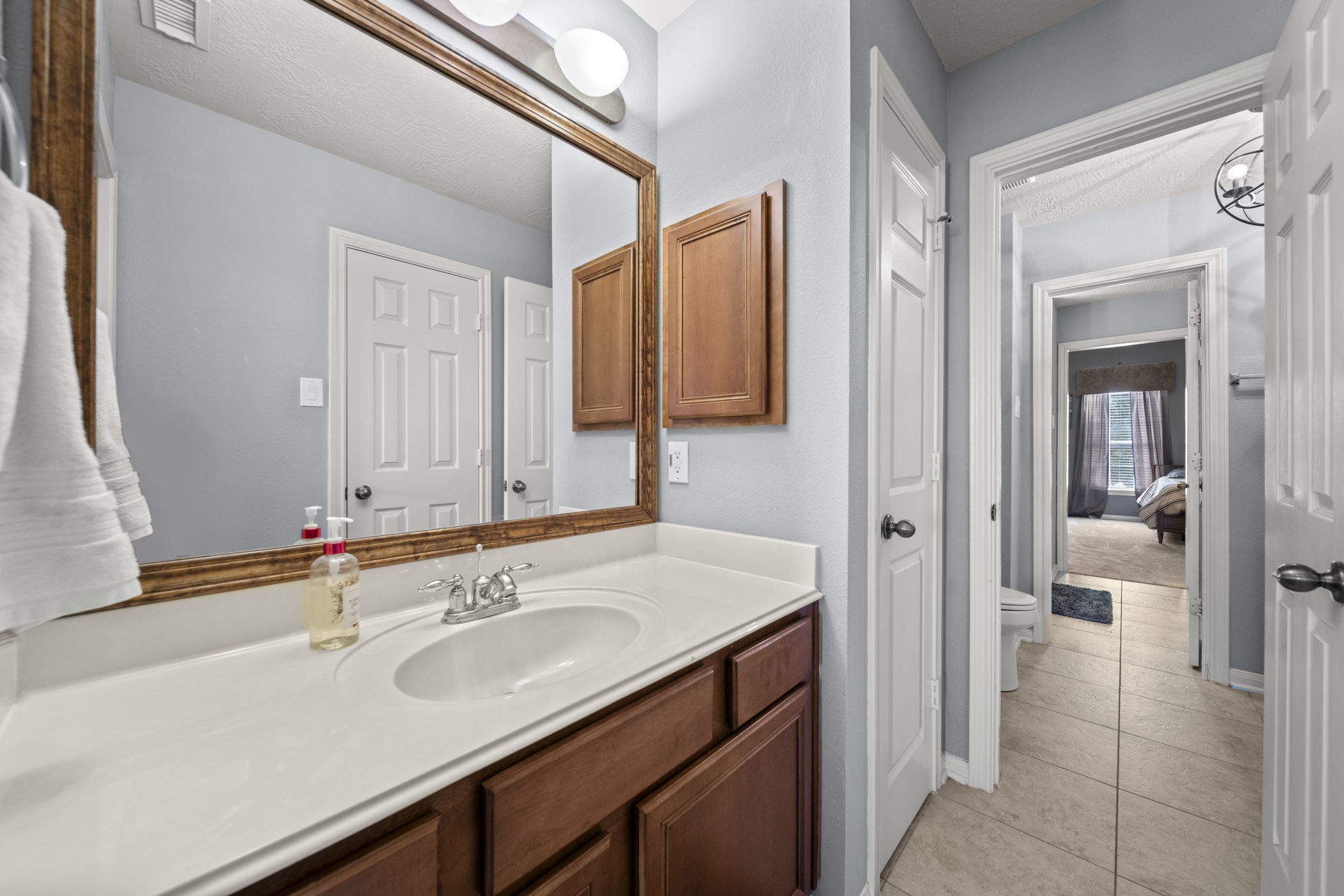 Jack & Jill bathroom with separate vanities and cultured marble countertops.