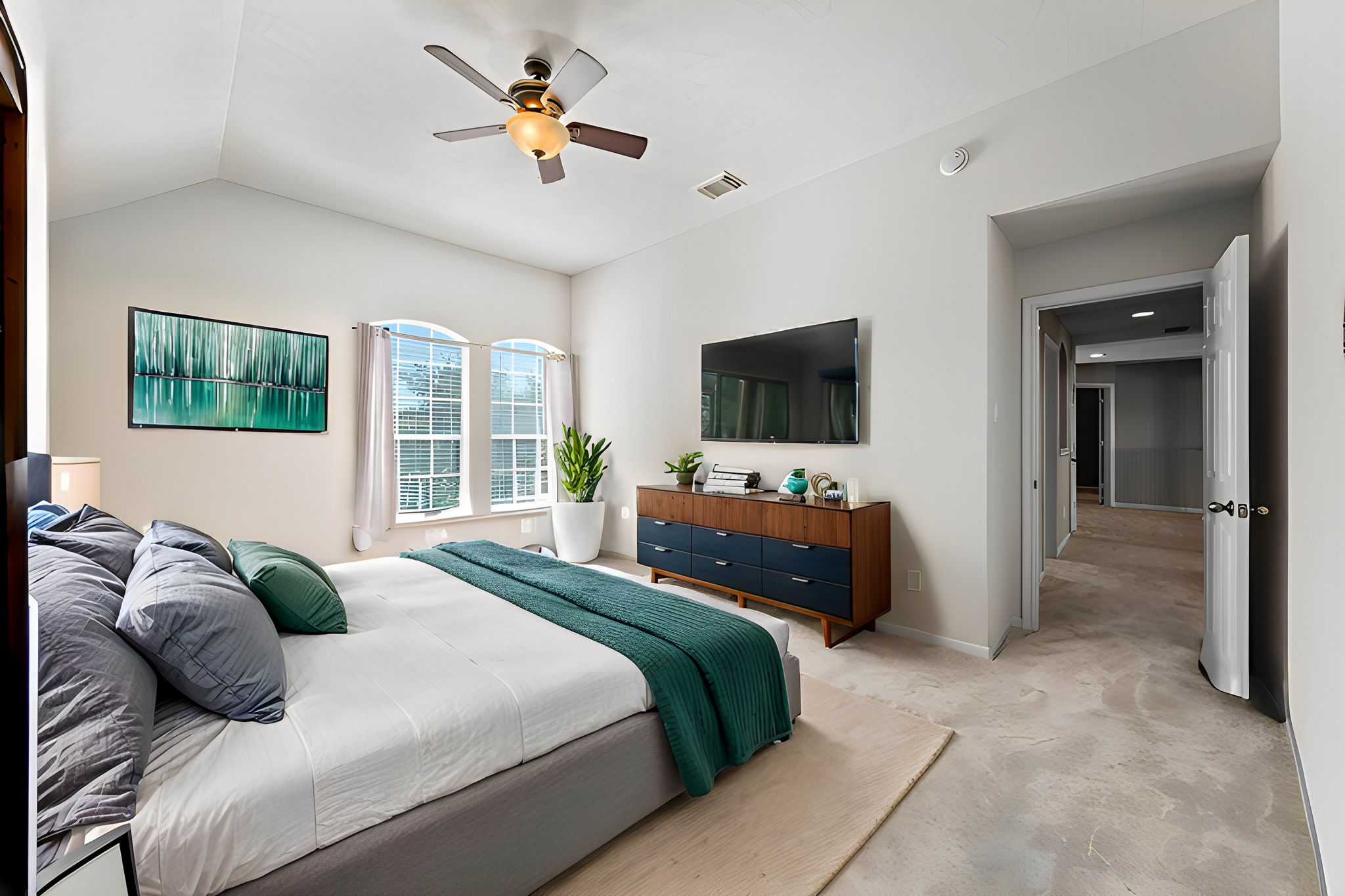 Secondary bedroom upstairs, facing the front of the home, with new carpet (2024), towering ceilings, a ceiling fan, walk-in closet & 2" blinds!