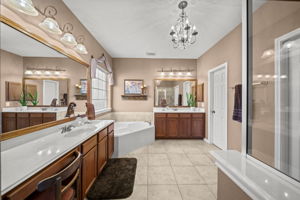 The primary en-suite with a chandelier, tile flooring and a walk-in closet!