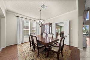 The dining area features laminate flooring, crown molding, 2" blinds, a chandelier and easy access to the kitchen.