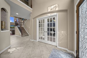 Gorgeous 2 story entryway with details of wrought iron staircase, art niches, arched entryways, towering ceilings and tile flooring!