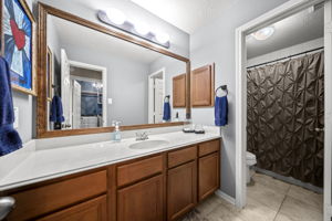 Secondary bathroom upstairs with cultured marble counter tops and a shower/tub combo.