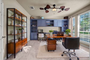 Home office with new carpet (2024) updated lighting/ceiling fan fixture, carpet, 2" blinds, and a walk in closet!