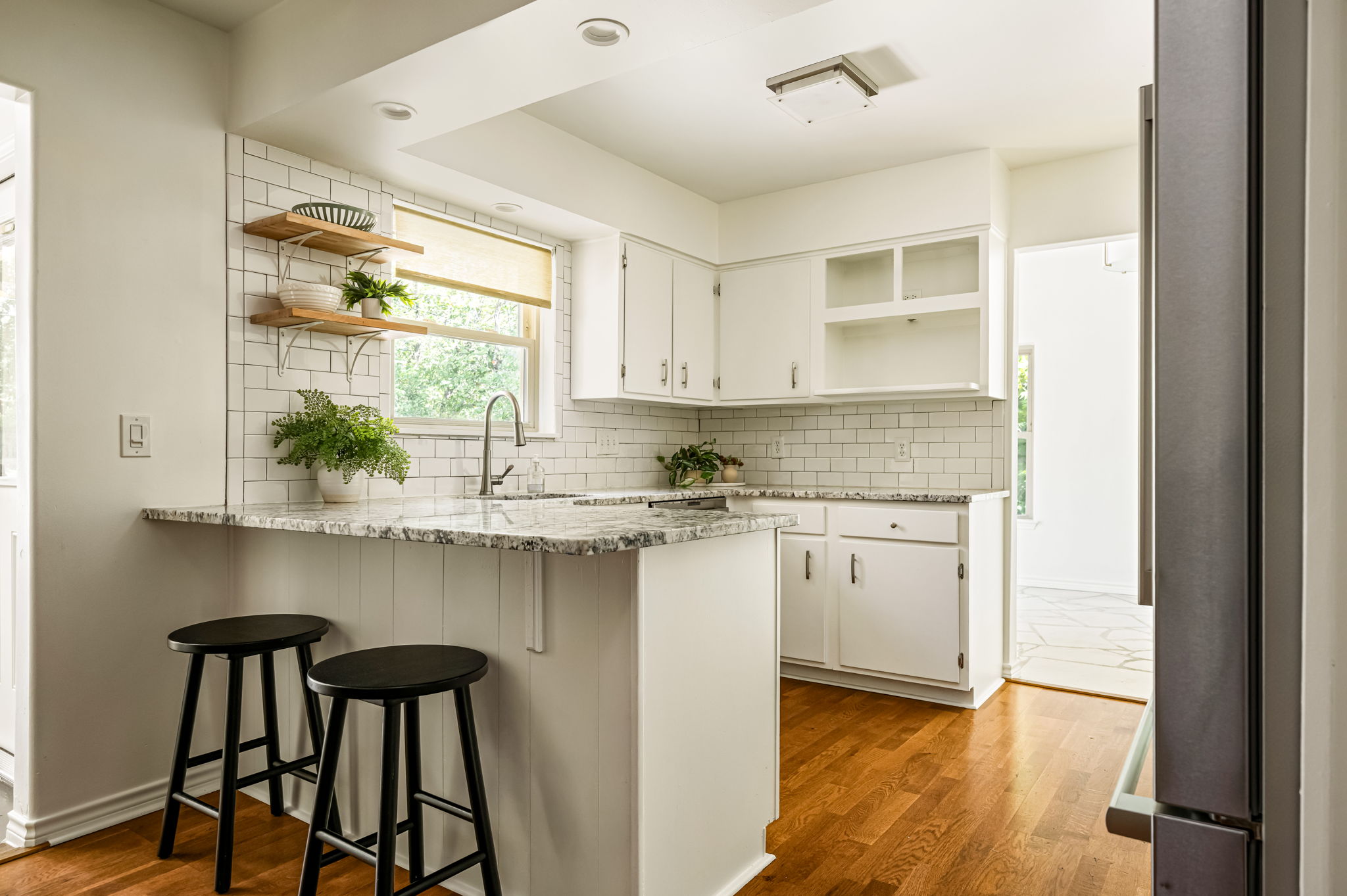 Remodeled white kitchen with stone counters