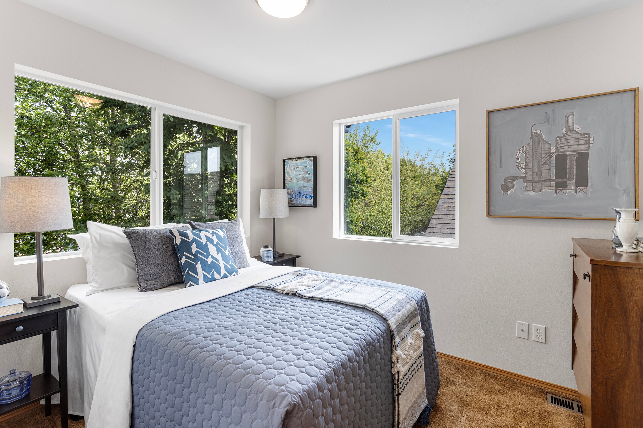 The spacious front bedroom has a treehouse feel with windows on two sides that offer views of the front courtyard and morning light from the east. It is conveniently located across the hall from the shared bathroom.
