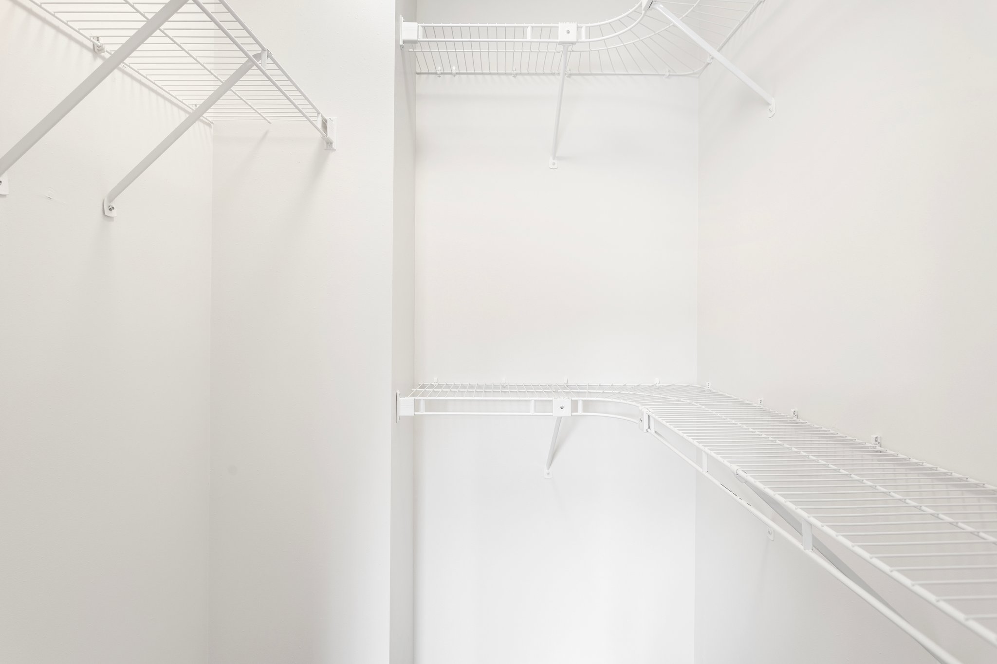 The large walk-in closet in the primary suite is a dream come true for anyone who loves fashion and organization. It has plenty of shelves and hanging rods to store and display your clothes and accessories.