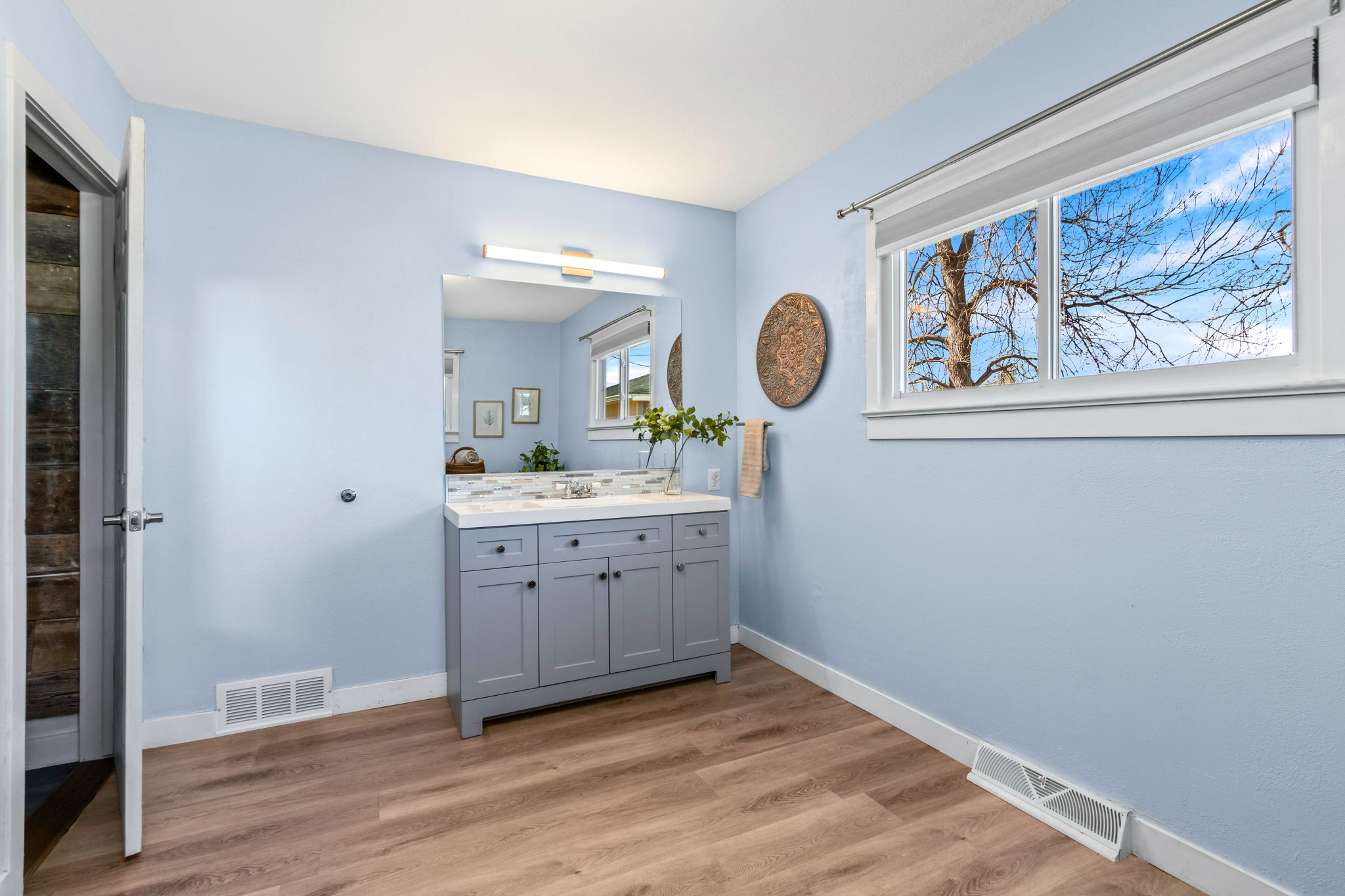 Laundry area and private primary bathroom are combined and located just off the primary bedroom