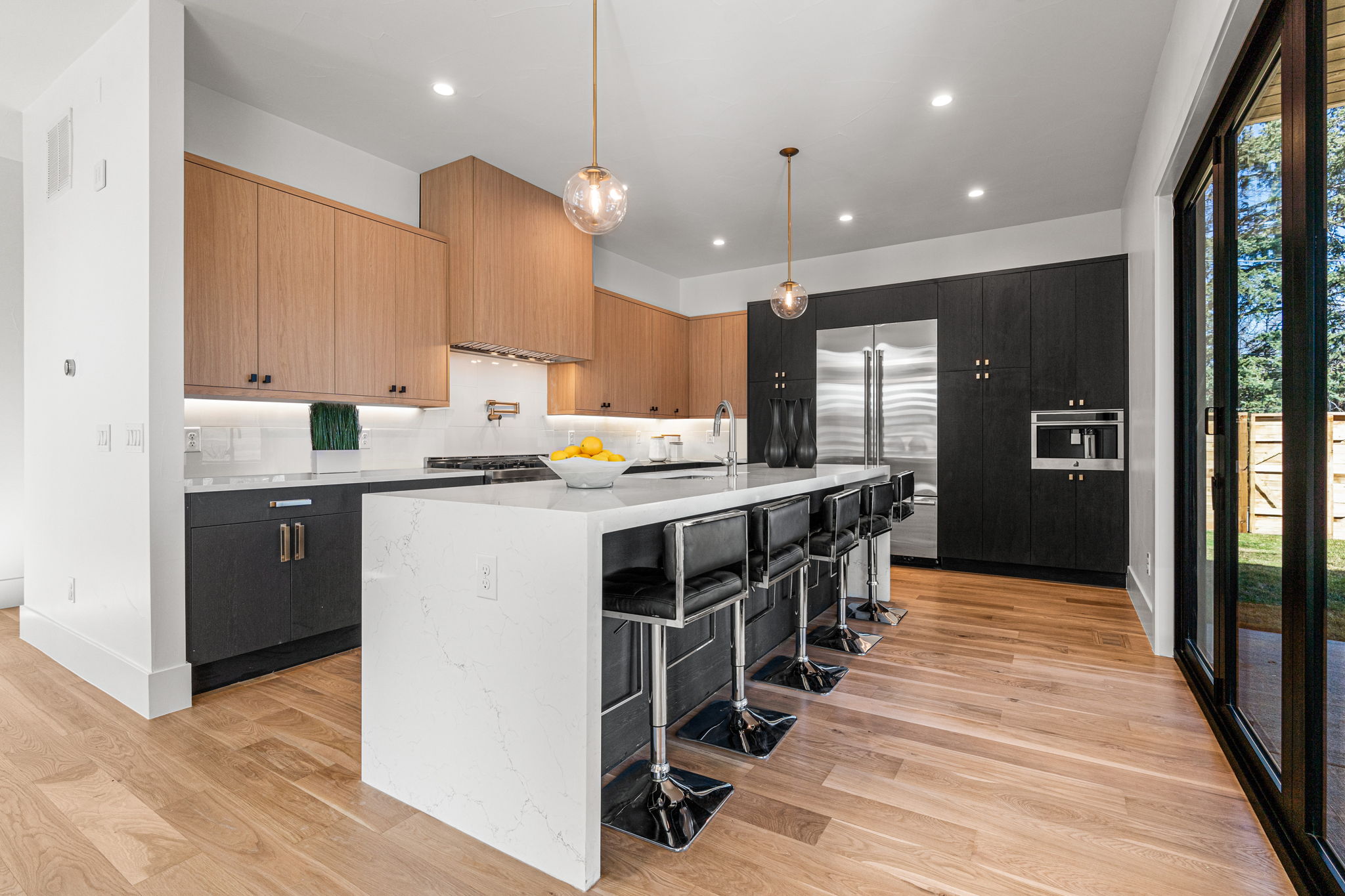 The chef-inspired kitchen showcases flat panel soft-close cabinets with under cabinet lighting, oversized eat-in island,, and top of the line appliances - including built-in espresso machine & pot filler.