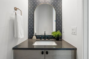 Chic powder room on main level with a standout tile wall.