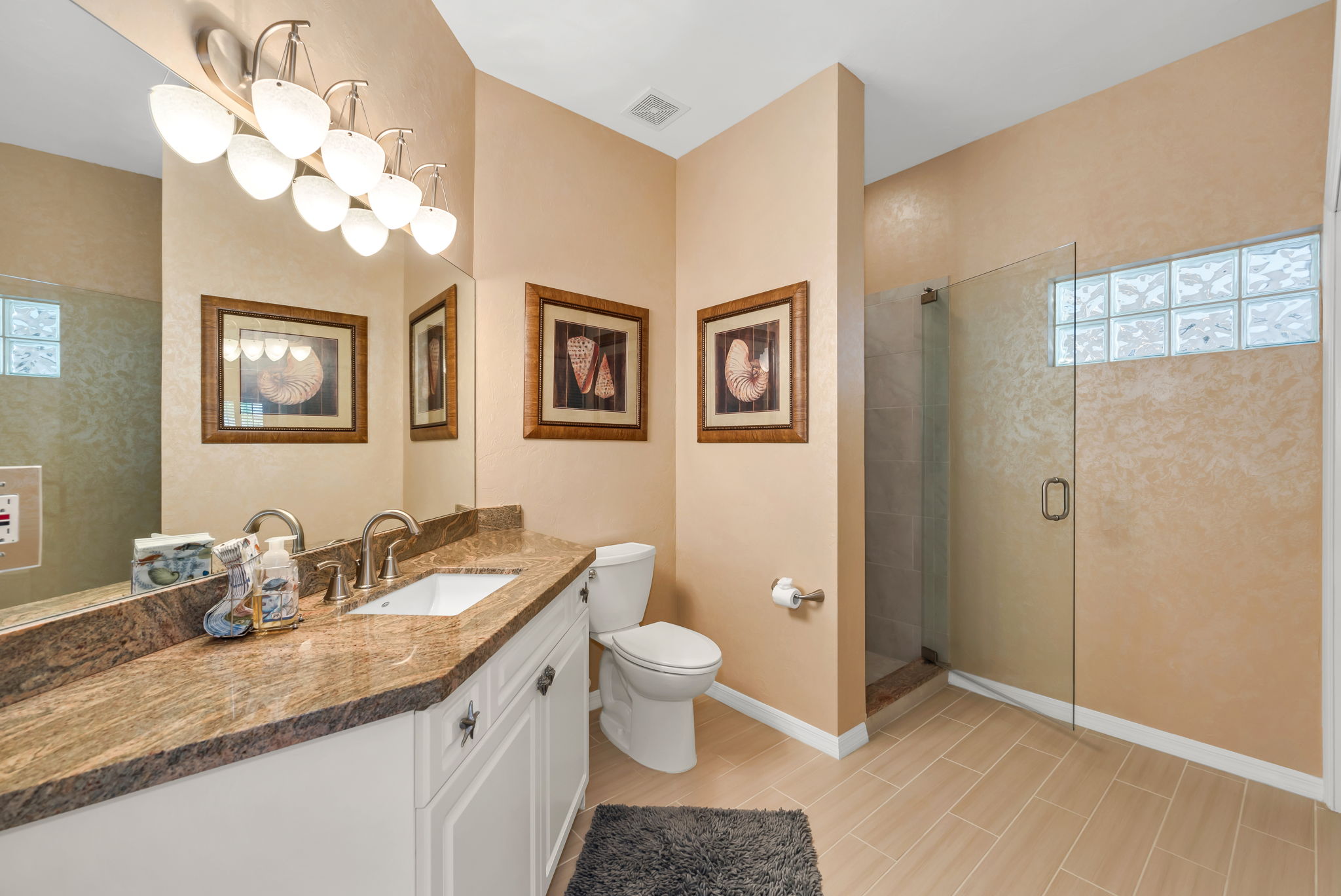 Guest Bathroom has granite countertops, seamless glass shower enclosure
