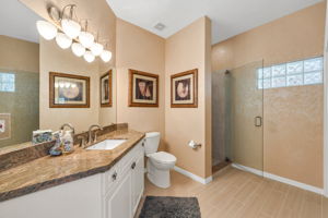 Guest Bathroom has granite countertops, seamless glass shower enclosure