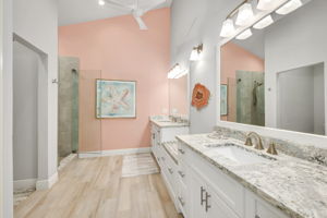 Primary Bathroom has been updated with Quartz countertops, Seamless Glass shower enclosure, and updated tile flooring