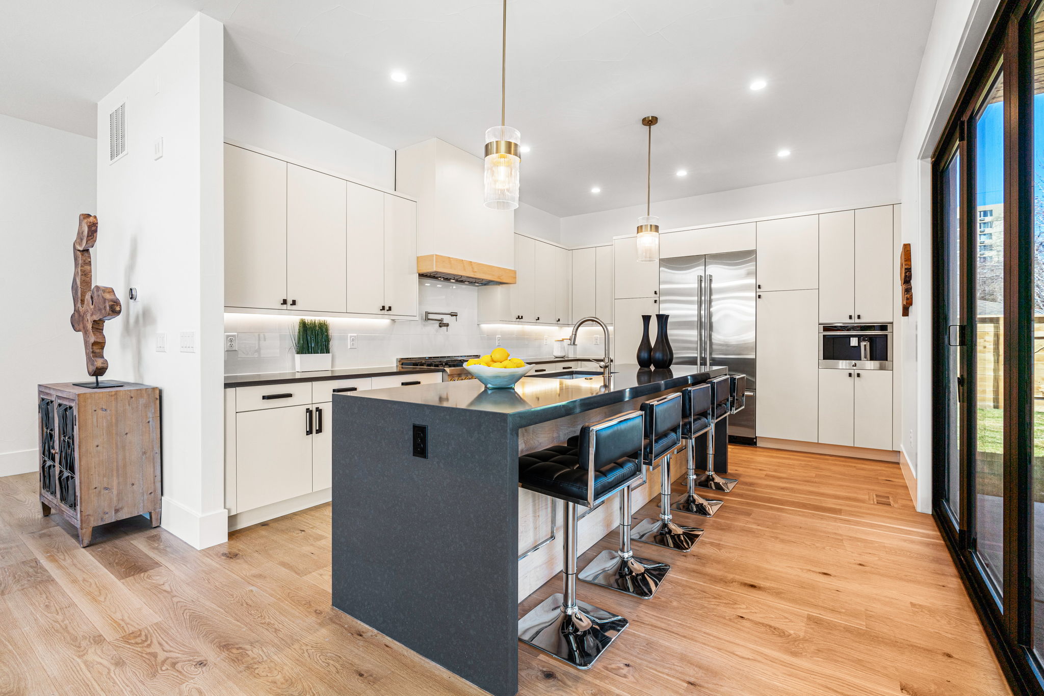 The chef-inspired kitchen showcases flat panel soft-close cabinets with under cabinet lighting, oversized eat-in island,, and top of the line appliances - including built-in espresso machine & pot filler.