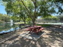 Picnic table near tennis courts, lagoon and walking path