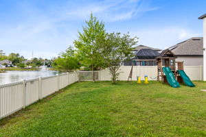 Large back yard with water view and play area.