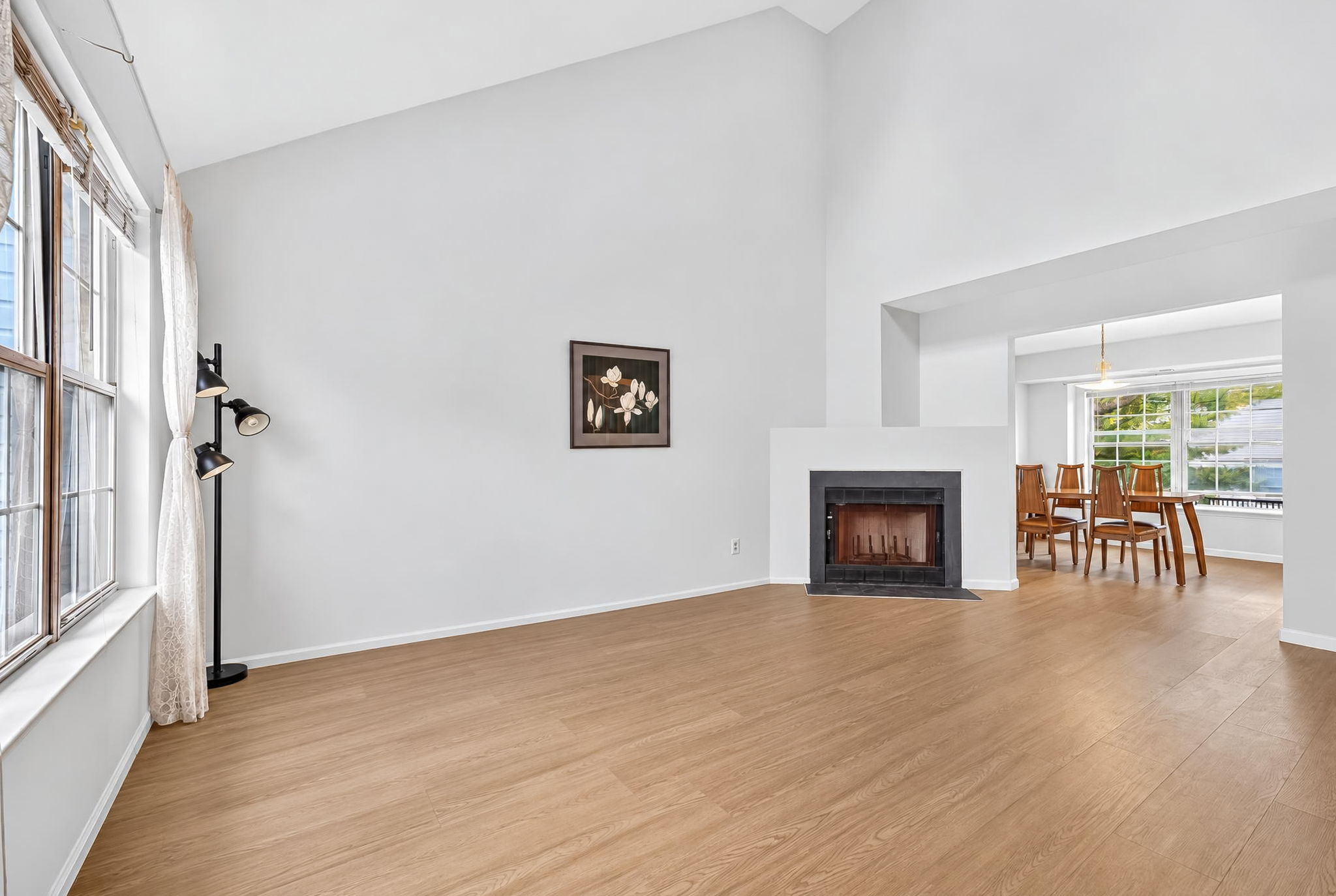 Living Room-Vaulted Ceiling Skylight 3 Side-by-Side Windows/Blinds Woodburning Fireplace LVP Flooring - 2025