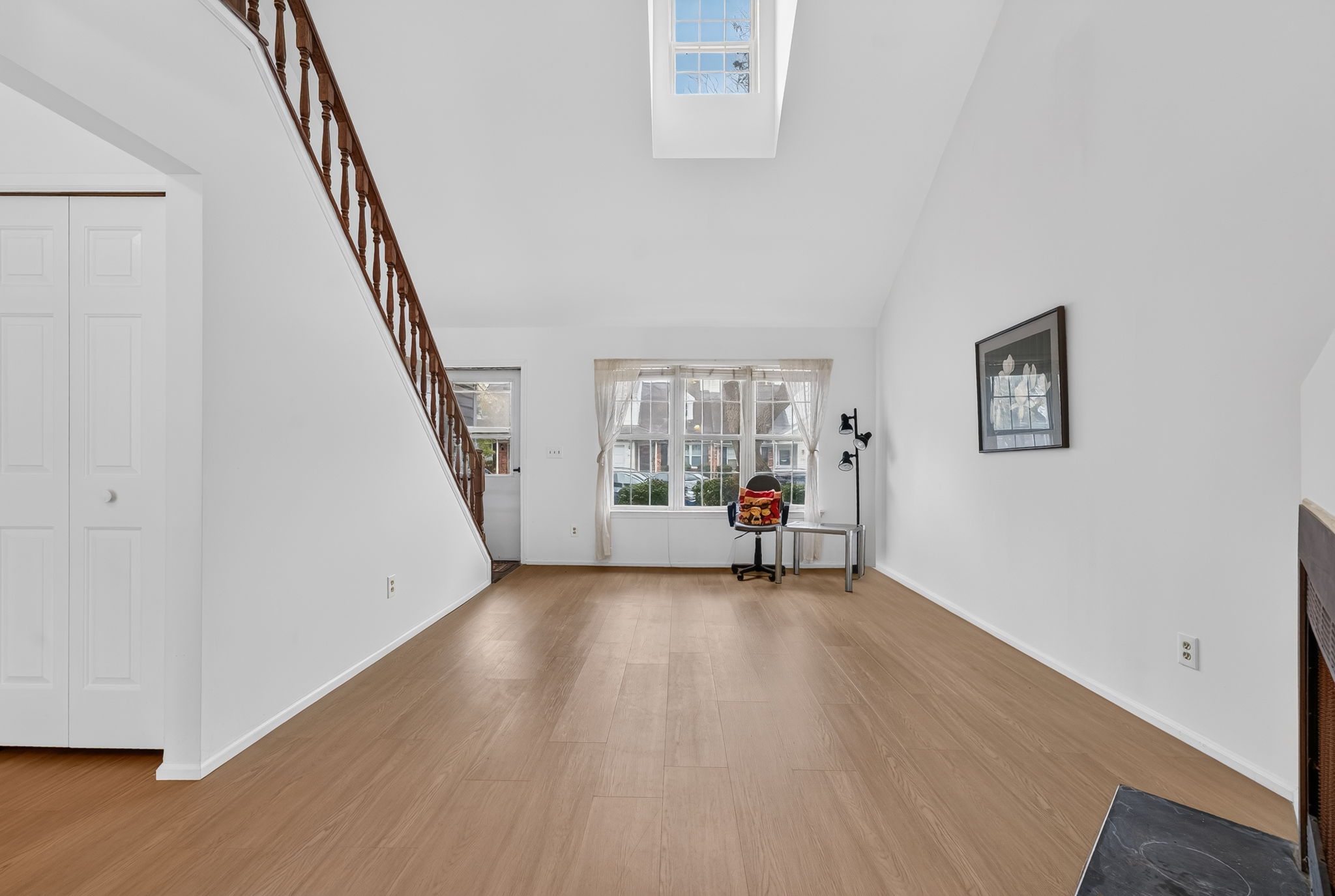 Living Room-Vaulted Ceiling Skylight 3 Side-by-Side Windows/Blinds Woodburning Fireplace LVP Flooring - 2025
