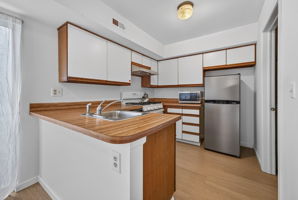 Eat-in Kitchen- European Cabinetry Wood-look Laminate Countertop Stainless Steel Sink Appliances Include: GE 5-Burner Range (2023)/Self Clean Oven/Vent Hood Dishwasher ?AS IS? Stainless Steel Refrigerator LVP Flooring - 2025