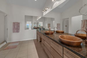 Primary Bathroom with teak cabinetry and copper sinks