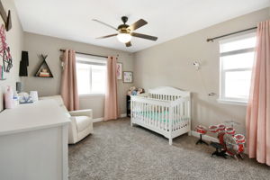 Bright 2nd bedroom with ceiling fan and 2 window