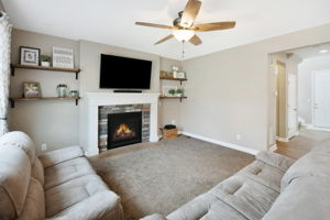 Great Room with custom shelving, gas fireplace and ceiling fan