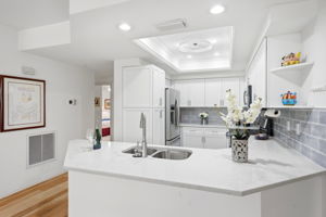 Newly remodeled kitchen. Quartz countertops, white cabinets, backsplash and combo light/fan