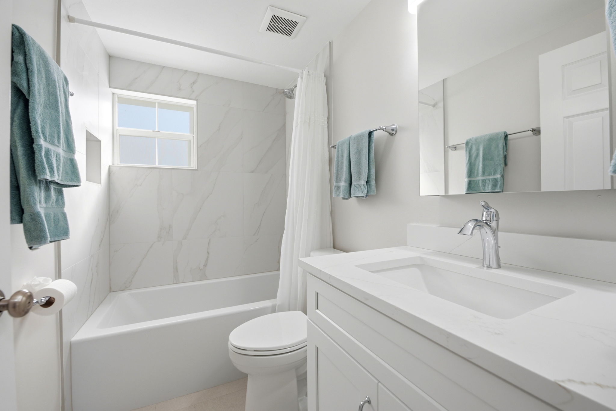 Guest bathroom with porcelain tile wall and quartz countertop vanity