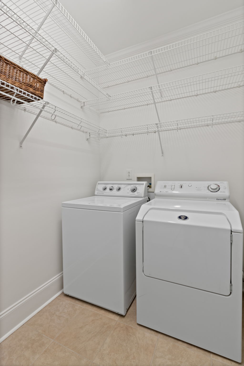 Washer/Dryer in true laundry room with storage shelves on 3 walls