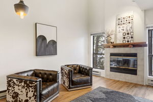 Sun-drenched living space with dramatic ceilings and inviting fireplace.