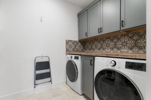 Laundry room is located in the center of the home with plenty of storage and counter space available. Not shown open shelving and space for extra refrigerator. Prep and plumbed for refrigerator.