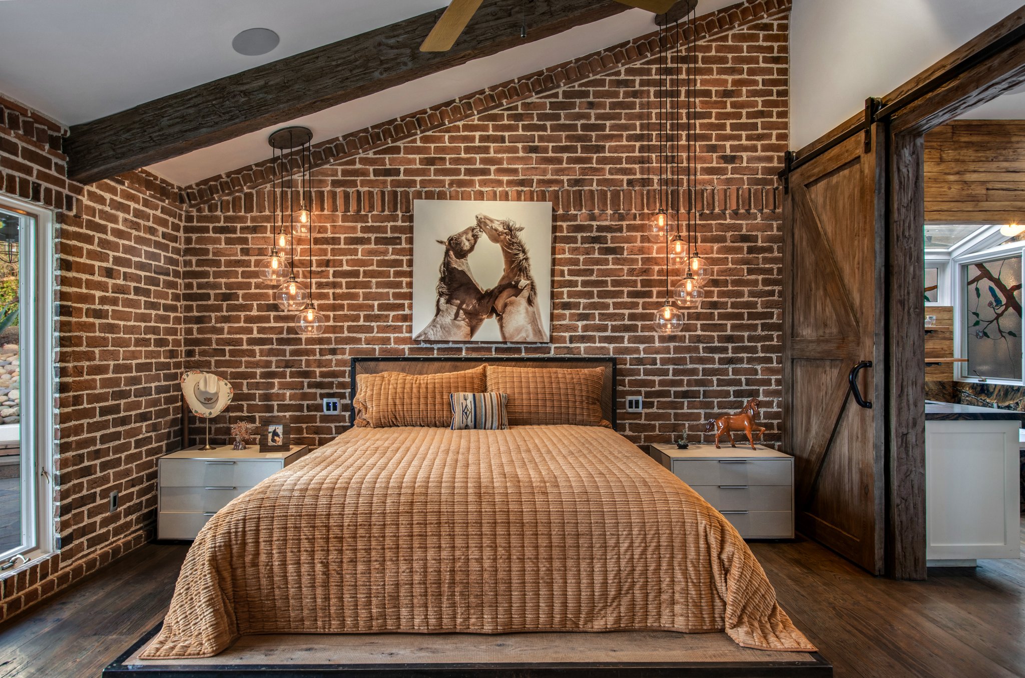 Owners suite - custom barn door divides the bedroom from the bathroom